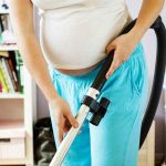 Pregnant woman mopping and cleaning